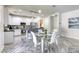 Contemporary kitchen featuring white cabinets, a large island, stainless steel appliances, and a dining area at 459 Astillero St, Las Vegas, NV 89138