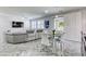 Open-concept living space with a gray sectional sofa, dining area, and modern tile flooring at 459 Astillero St, Las Vegas, NV 89138