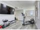 Open loft space with exercise equipment, grey wood floors, a large TV, and bright natural light at 459 Astillero St, Las Vegas, NV 89138