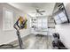 Bright office with grey wood floors, white built-ins, modern desk, ceiling fan, and exercise equipment at 459 Astillero St, Las Vegas, NV 89138