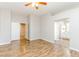 Spacious main bedroom featuring an ceiling fan, wood-look floors, and closet doors visible leading to the en suite bathroom at 472 Tiger Lily Way, Henderson, NV 89015