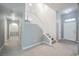 Inviting entryway features modern gray walls, wood-look floors, a white staircase, and high ceilings, creating a bright and open space at 5133 Burr Oak Dr, Las Vegas, NV 89130