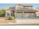 Two-story home featuring a two-car garage and desert landscaping at 5133 Burr Oak Dr, Las Vegas, NV 89130