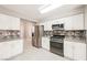 Bright kitchen boasts stainless steel appliances, white cabinets, and stylish tile backsplash at 5133 Burr Oak Dr, Las Vegas, NV 89130