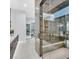 Bathroom showcasing sleek marble design, walk-in glass shower, modern fixtures, and vanity with ample counter space at 5400 Mello Ave, Las Vegas, NV 89131