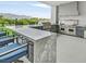 Covered outdoor kitchen with a grill, counter seating, stainless steel appliances, and a modern design at 5400 Mello Ave, Las Vegas, NV 89131