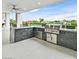Outdoor kitchen features a stainless steel grill, counter seating, and sleek cabinetry at 5400 Mello Ave, Las Vegas, NV 89131