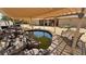 Outdoor oasis featuring covered patio, stone accents, and a tranquil koi pond with mature desert landscaping at 5480 Lincolnwood Ct, Pahrump, NV 89061