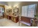 Bathroom vanity with double sinks, decorative mirrors, and stylish fixtures at 5480 Lincolnwood Ct, Pahrump, NV 89061