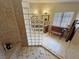 Bathroom featuring tile floors, glass block shower, vanity, mirror, and a cozy wooden bench at 5480 Lincolnwood Ct, Pahrump, NV 89061