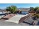 Single-story home with a tile roof, desert landscaping, and a concrete driveway on a sunny day at 5480 Lincolnwood Ct, Pahrump, NV 89061