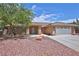 Charming single-story home featuring a well-manicured yard with decorative rocks and a two-car garage at 5480 Lincolnwood Ct, Pahrump, NV 89061