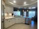 Well-lit kitchen featuring white cabinetry, marble countertops, and stainless steel dishwasher at 5480 Lincolnwood Ct, Pahrump, NV 89061