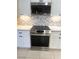 Close up of stainless steel range with cooktop and oven set into white cabinets with modern hardware at 5480 Lincolnwood Ct, Pahrump, NV 89061