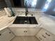 Close up of kitchen sink with black faucet and grid, white countertop, and matching backsplash at 5480 Lincolnwood Ct, Pahrump, NV 89061
