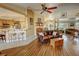 Inviting living room featuring a ceiling fan, wood floors, and a smooth transition into the kitchen area at 5480 Lincolnwood Ct, Pahrump, NV 89061