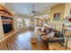 Open living room with hardwood floors, large windows, built-in storage, and comfortable leather seating at 5480 Lincolnwood Ct, Pahrump, NV 89061