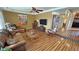 Spacious living room featuring a ceiling fan, rich hardwood floors, and comfortable leather seating at 5480 Lincolnwood Ct, Pahrump, NV 89061