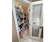 Walk-in pantry with shelving for storage and decorative frosted glass door at 5480 Lincolnwood Ct, Pahrump, NV 89061