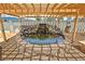 Relaxing backyard pond with rock waterfall feature beneath a pergola creating a tranquil outdoor oasis at 5480 Lincolnwood Ct, Pahrump, NV 89061