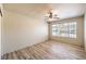 Light-filled bedroom featuring wood-look flooring, a ceiling fan, and a large window with neighborhood views at 5710 E Tropicana Ave # 1114, Las Vegas, NV 89122