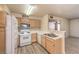 Updated kitchen with wood cabinets, white appliances, and eat-in bar at 5710 E Tropicana Ave # 1114, Las Vegas, NV 89122