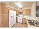 Bright kitchen features light wood cabinets, white appliances, and laminate wood flooring at 5710 E Tropicana Ave # 1114, Las Vegas, NV 89122