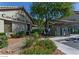 Community building entrance with colorful flowers, lush shrubs and verdant green trees in background at 5710 E Tropicana Ave # 2178, Las Vegas, NV 89122