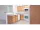 Well-maintained kitchen featuring wood cabinets, white appliances, and functional layout for easy meal preparation at 5710 E Tropicana Ave # 2178, Las Vegas, NV 89122