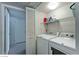 Laundry room with a washer, dryer, storage shelf, and bifold doors at 5710 E Tropicana Ave # 2178, Las Vegas, NV 89122