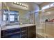 Bright bathroom with double sink vanity, granite countertops and walk-in shower at 5854 Olivine Falls Ave, Las Vegas, NV 89130