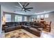 Spacious living room featuring a large sectional couch, fan, and dining room view at 5854 Olivine Falls Ave, Las Vegas, NV 89130