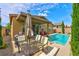 Inviting backyard pool area with a covered patio and outdoor seating, perfect for entertaining at 5854 Olivine Falls Ave, Las Vegas, NV 89130