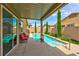 Inviting backyard pool with covered patio, outdoor seating and beautiful landscaping at 5854 Olivine Falls Ave, Las Vegas, NV 89130