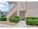 Residential building exterior with stairs leading to a doorway, surrounded by neatly trimmed shrubs and gravel at 6480 Annie Oakley Dr # 112, Las Vegas, NV 89120