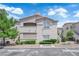 View of the building shows a beige facade with a window, patio, and well-maintained landscaping at 6480 Annie Oakley Dr # 112, Las Vegas, NV 89120