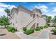 Exterior of a multi-story residential building with a stucco finish, complemented by lush green landscaping at 6480 Annie Oakley Dr # 112, Las Vegas, NV 89120