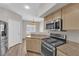 Modern kitchen with stainless steel appliances, light wood cabinets, and beautiful natural light through shuttered windows at 6480 Annie Oakley Dr # 112, Las Vegas, NV 89120