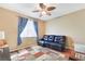 Comfortable bedroom with a ceiling fan, a dark leather sofa, and neutral-colored walls at 6712 Tattler Dr, North Las Vegas, NV 89084