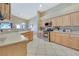 Spacious kitchen with light wood cabinets, stainless steel appliances, ample counter space and tile floors at 6712 Tattler Dr, North Las Vegas, NV 89084