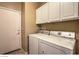 Functional laundry room with washer, dryer, and overhead cabinets at 6712 Tattler Dr, North Las Vegas, NV 89084
