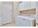 Clean laundry area with a washer, dryer, storage cabinets, and access to the garage at 6712 Tattler Dr, North Las Vegas, NV 89084