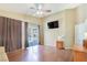 Spacious living room with hardwood floors, a mounted TV, and a sliding glass door to the pool at 6712 Tattler Dr, North Las Vegas, NV 89084