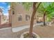 A charming backyard features a well-kept stone area with trees and an inviting patio under an upper-level balcony at 6739 Quapaw St, Las Vegas, NV 89149