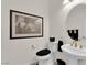 Well-lit bathroom featuring a pedestal sink, toilet, and framed art, offering a clean and simple design at 6739 Quapaw St, Las Vegas, NV 89149