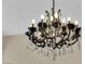 Close up of ornate chandelier with crystals and candelabra lights adding elegance to the home at 6739 Quapaw St, Las Vegas, NV 89149