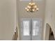 Well-lit foyer featuring a chandelier, glass front door and view of the upper level at 6739 Quapaw St, Las Vegas, NV 89149