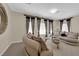 Comfortable sitting room with curved sofas, decorative curtains, and neutral tones at 6739 Quapaw St, Las Vegas, NV 89149