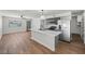 Well-lit open concept kitchen and living area featuring a modern island, stainless appliances, and wood-look flooring at 728 Carpenter Dr, Las Vegas, NV 89107