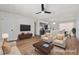 Bright, staged living room with modern furnishings, ceiling fan and seamlessly flowing into a kitchen with island seating at 728 Carpenter Dr, Las Vegas, NV 89107